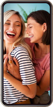 A mobile screen showing a blonde lady with a striped top and a brunette lady with a pink top smiling and hugging each other